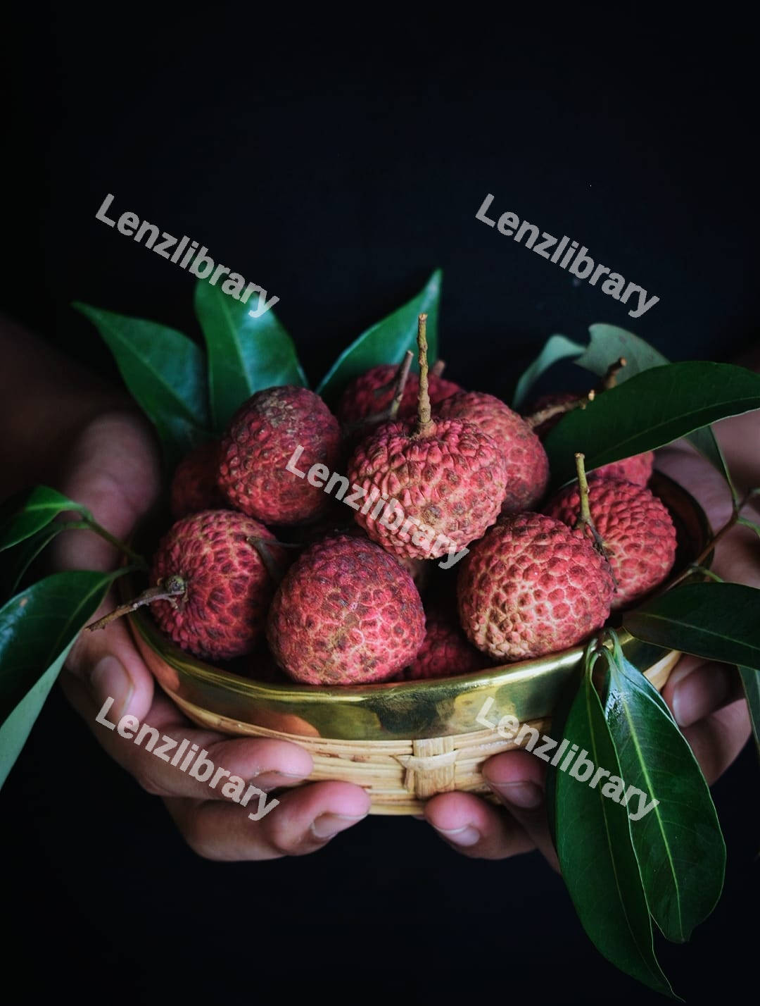 A hand holding a Lychee fruit